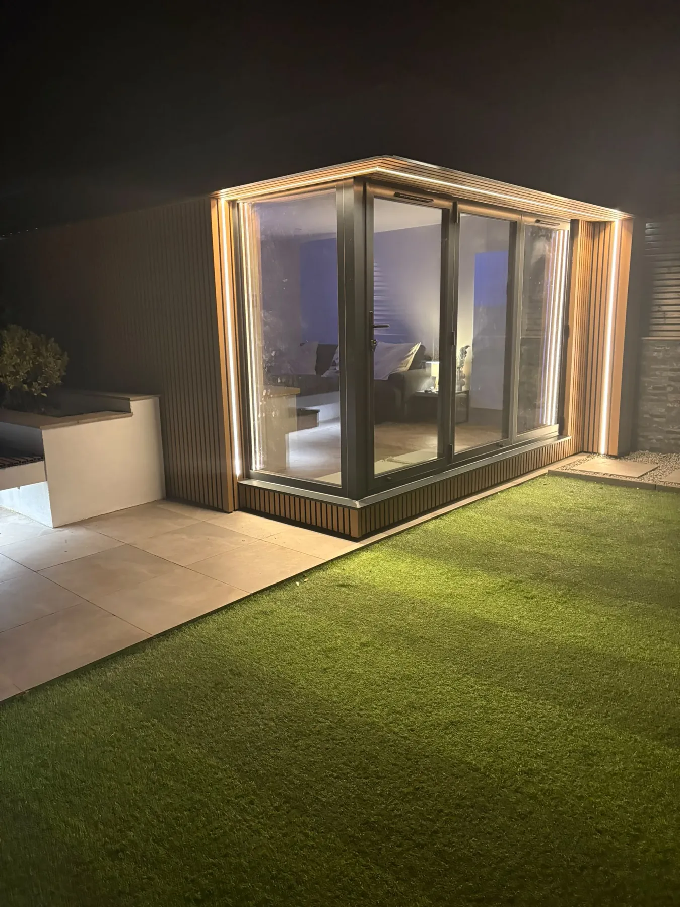 Finished Arden & Oak garden room at night with LED-lit soffit and corner glazing